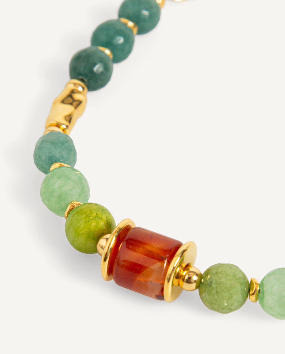 Detalle del collar corto Braisa verde de Emolo con cuentas verdes facetadas, cuenta central naranja y separadores dorados