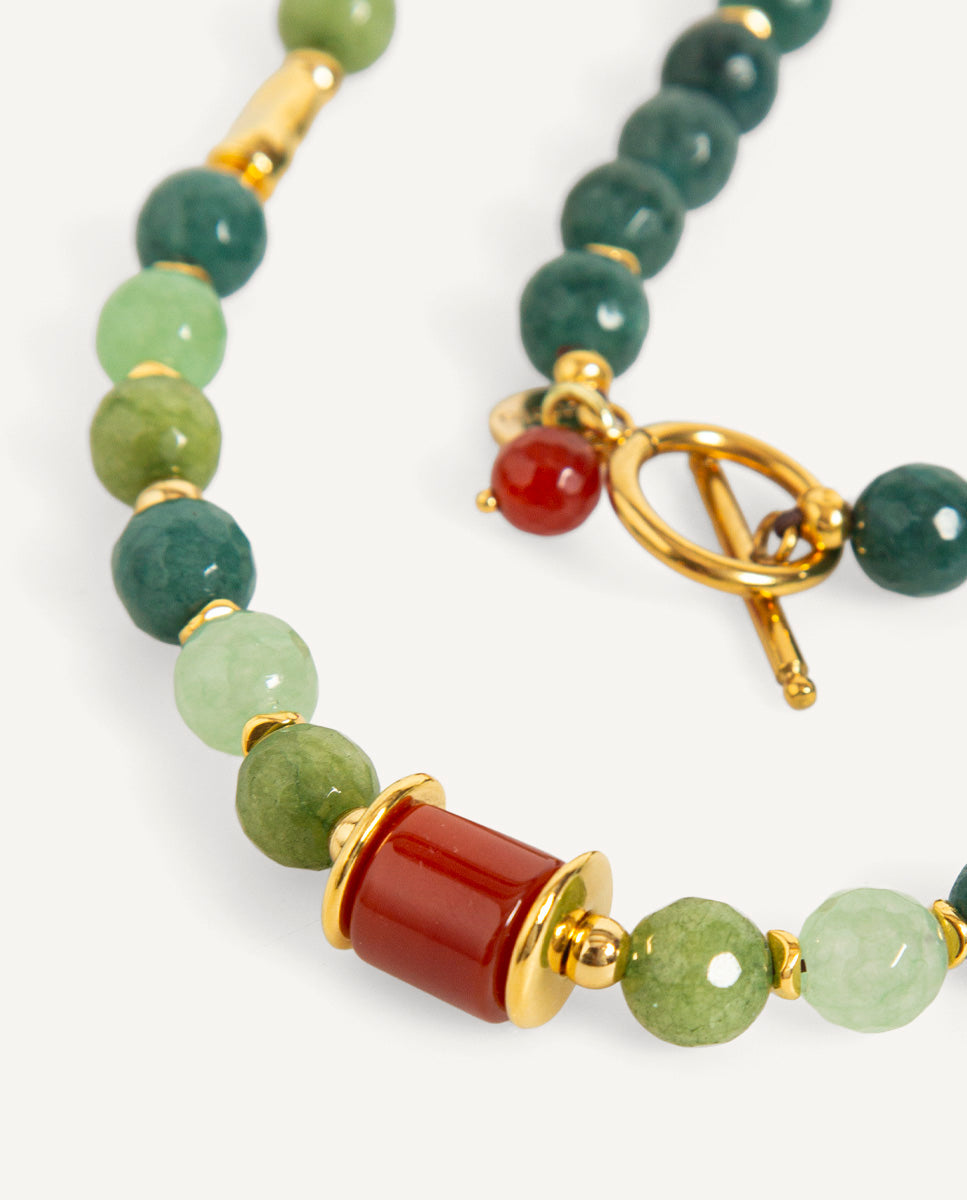 Detalle del collar largo Braisa verde de Emolo con cuentas facetadas de varios tonos verdes, cuenta roja y separadores dorados