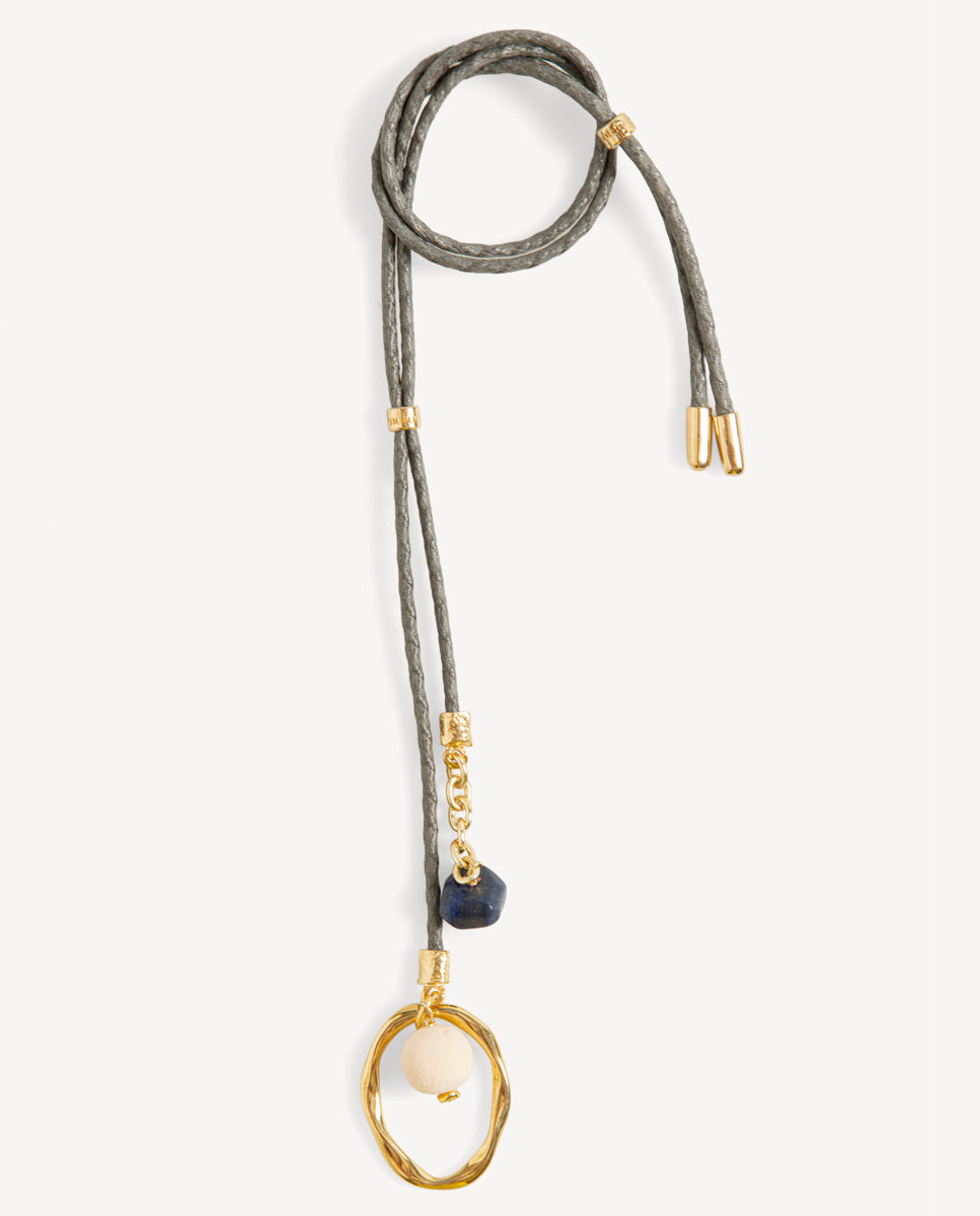 Collar largo Nimbo Monsul gris de Emolo con cordón trenzado, aro dorado irregular y cuentas blanca y azul oscuro