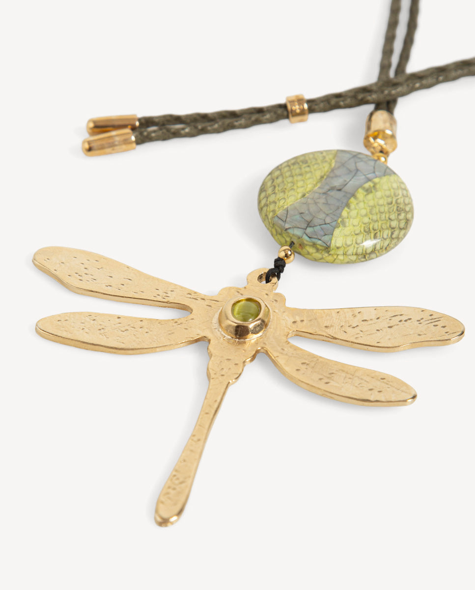Detalle del collar Libet Monsul verde de Emolo con libélula dorada, piedra verde redonda y pieza ovalada con estampado de escamas