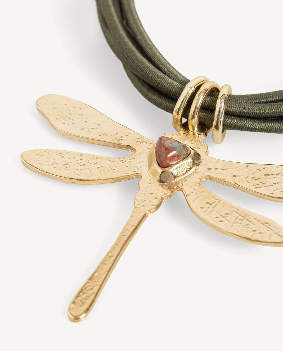 Detalle del collar Libet Ency de Emolo con libélula dorada texturizada, unakita triangular y cordones verde oliva