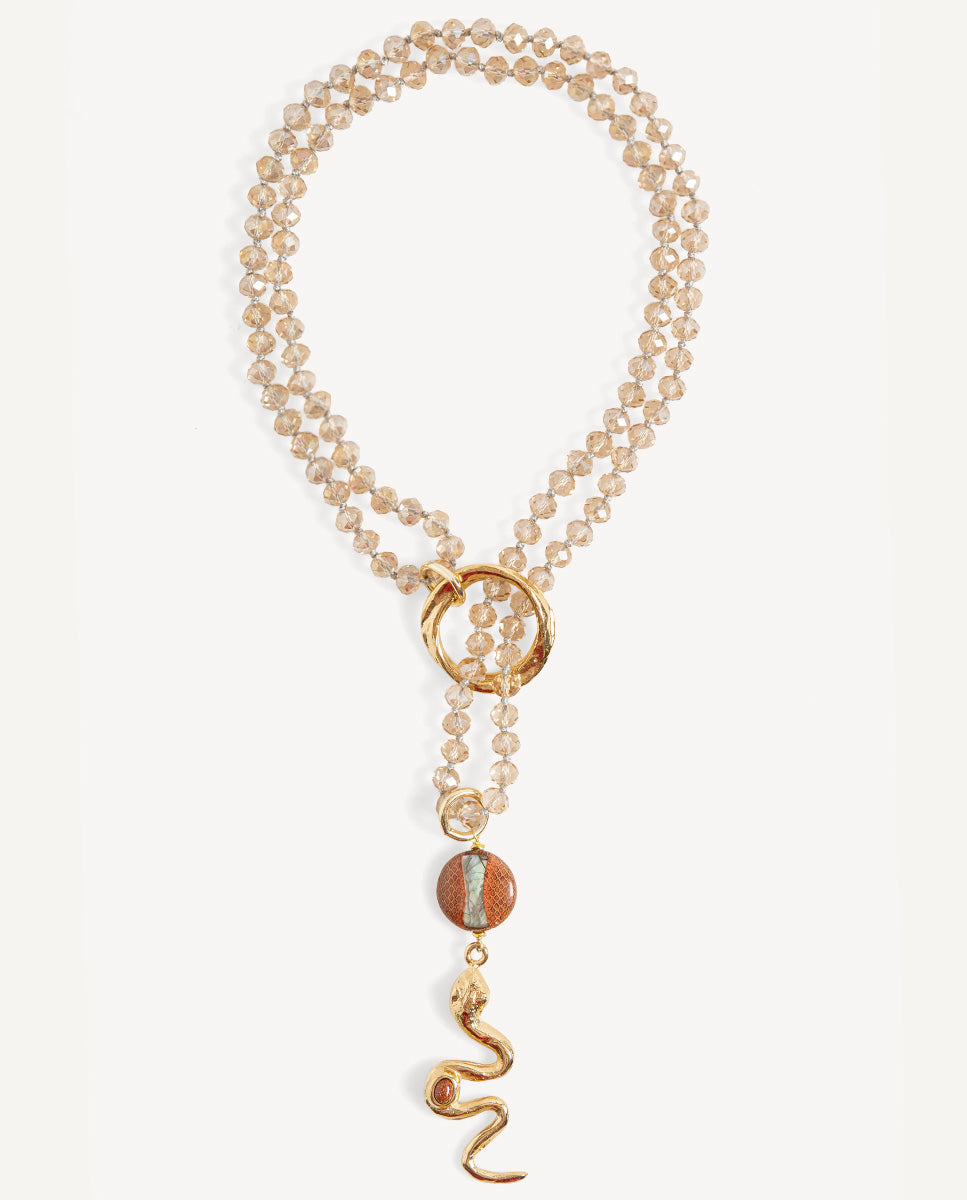 Collar largo Odri Ambera translúcido de Emolo con cuentas claras facetadas, aro dorado y colgante de serpiente