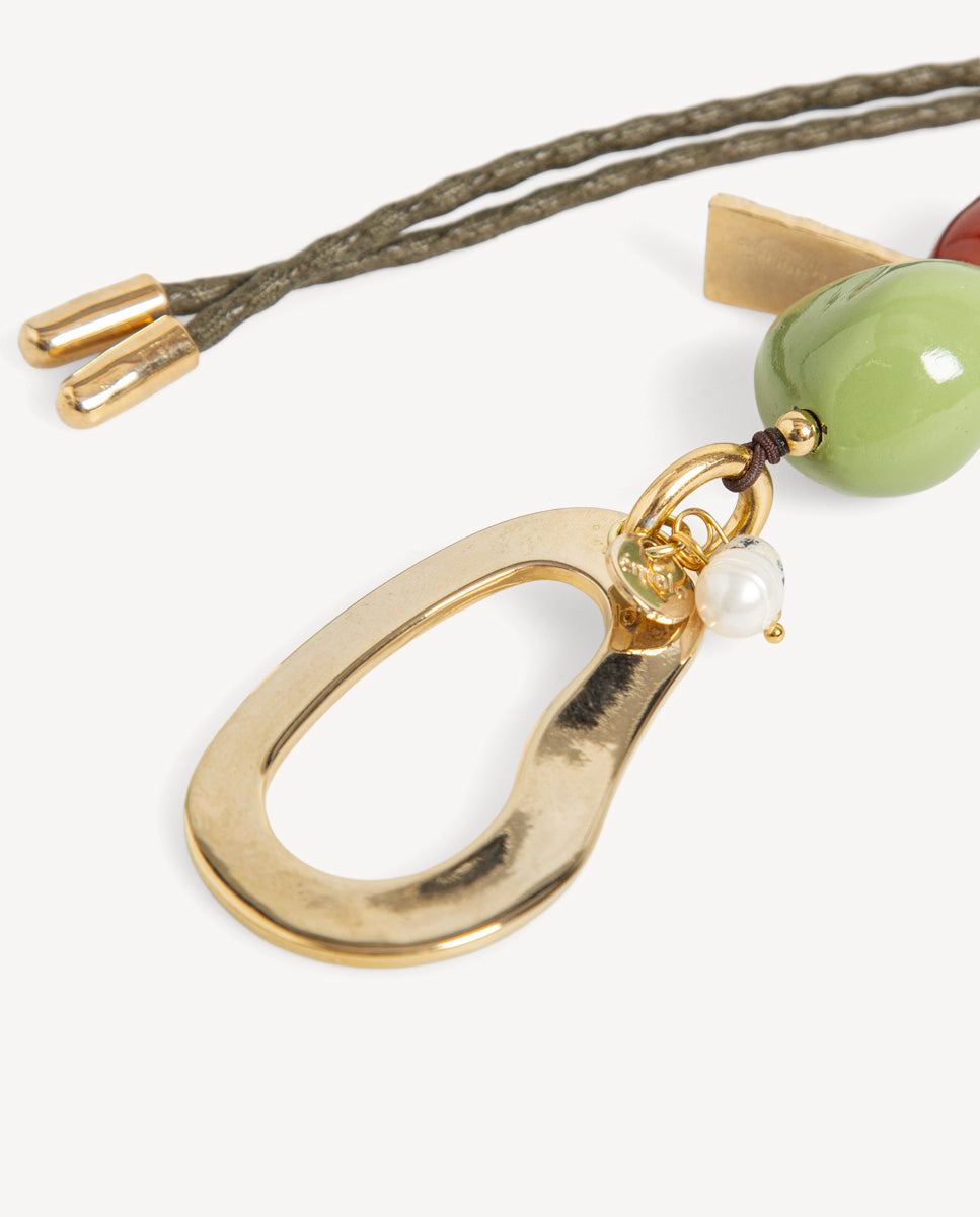 Detalle del collar Hanner verde de Emolo con colgante dorado en forma de gota calada, cuenta verde y pequeña cuenta blanca