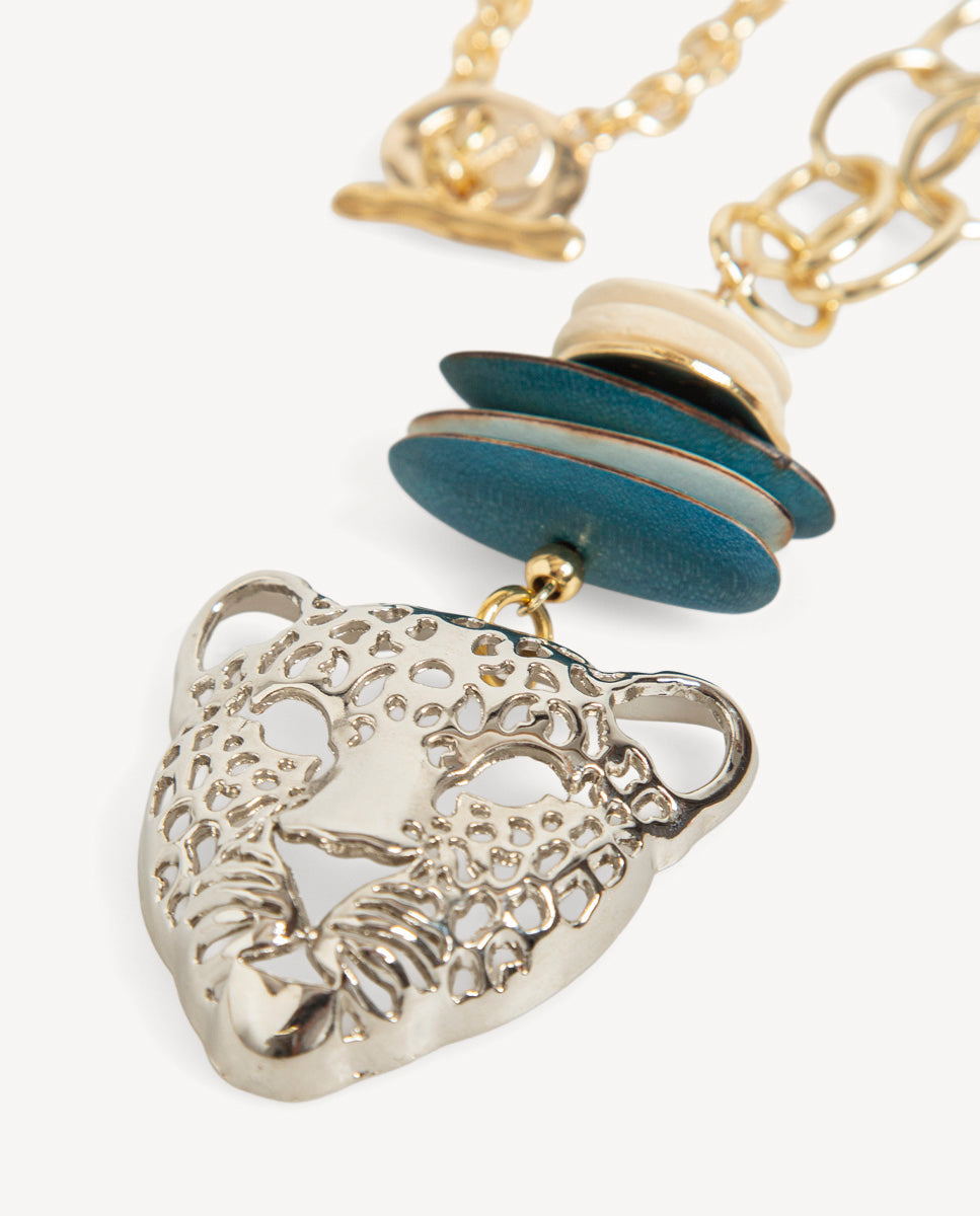 Detalle del collar Tigre de Emolo con cabeza de felino plateada, discos azules y cadena dorada