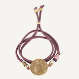 Collar y pulsera color berenjena con moneda dorada