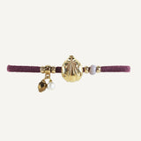 Pulsera ajustable color berenjena con pieza dorada forma mariquita