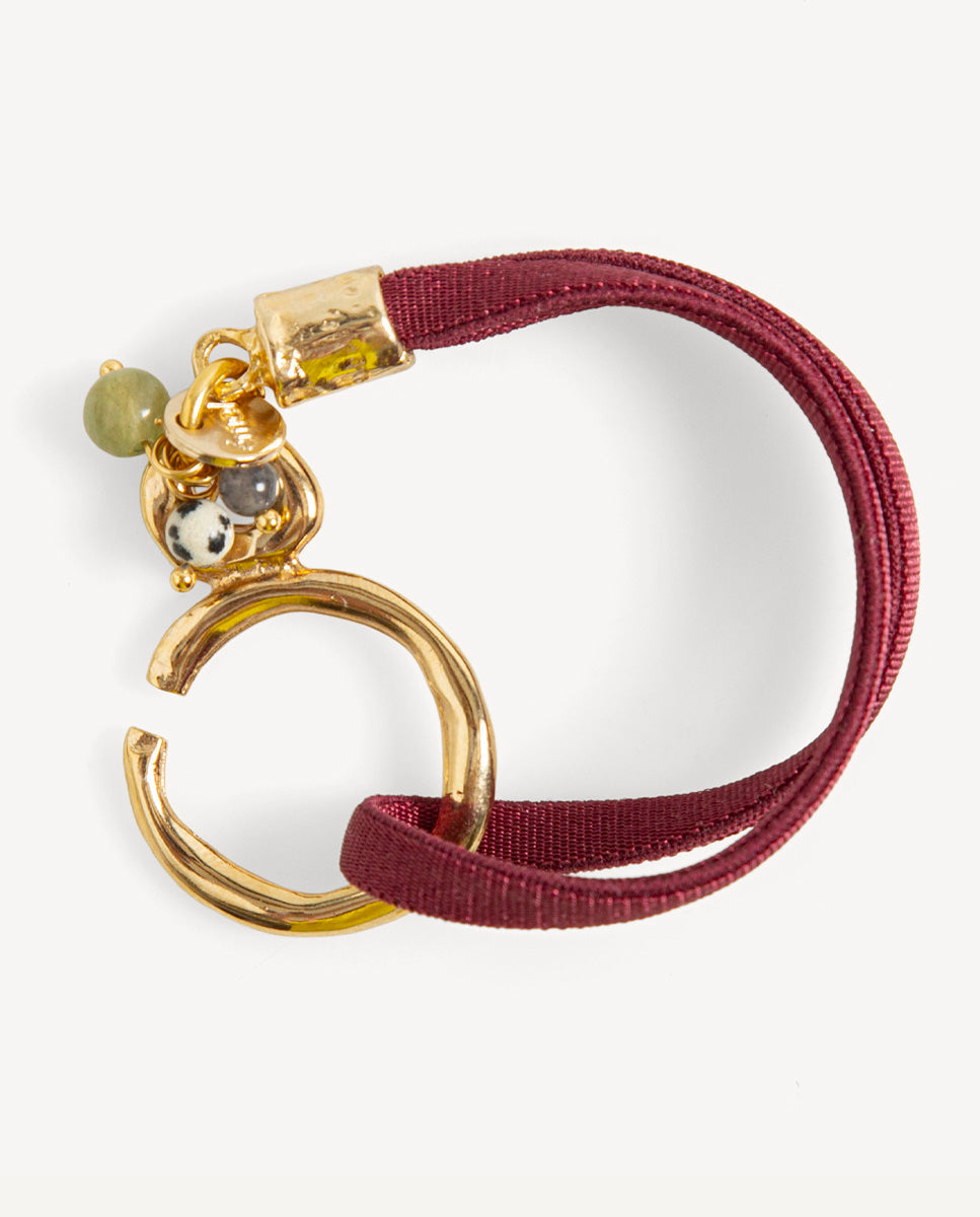 Pulsera Sasha burdeos de Emolo con cordón doble, aro dorado y pequeñas cuentas de colores junto al cierre