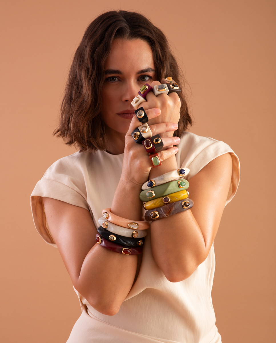 Modelo con anillos oversize y pulseras rígidas de Émolo en varios colores y detalles dorados