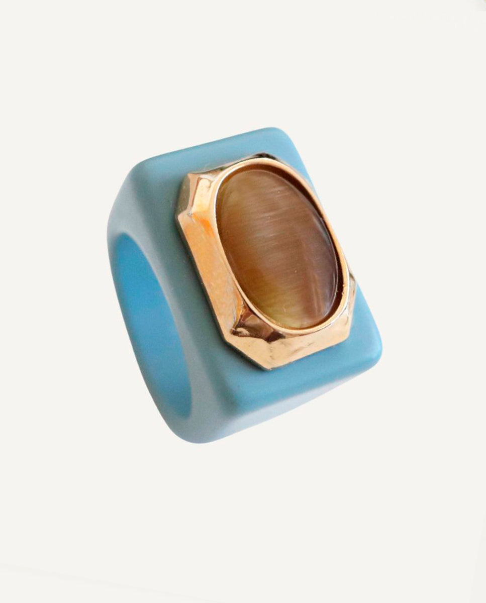 Anillo oversize de mujer en azul nórdico con piedra natural de selenita fumé de talla ovalada XXL y detalles dorados, hecho a mano por Emolo