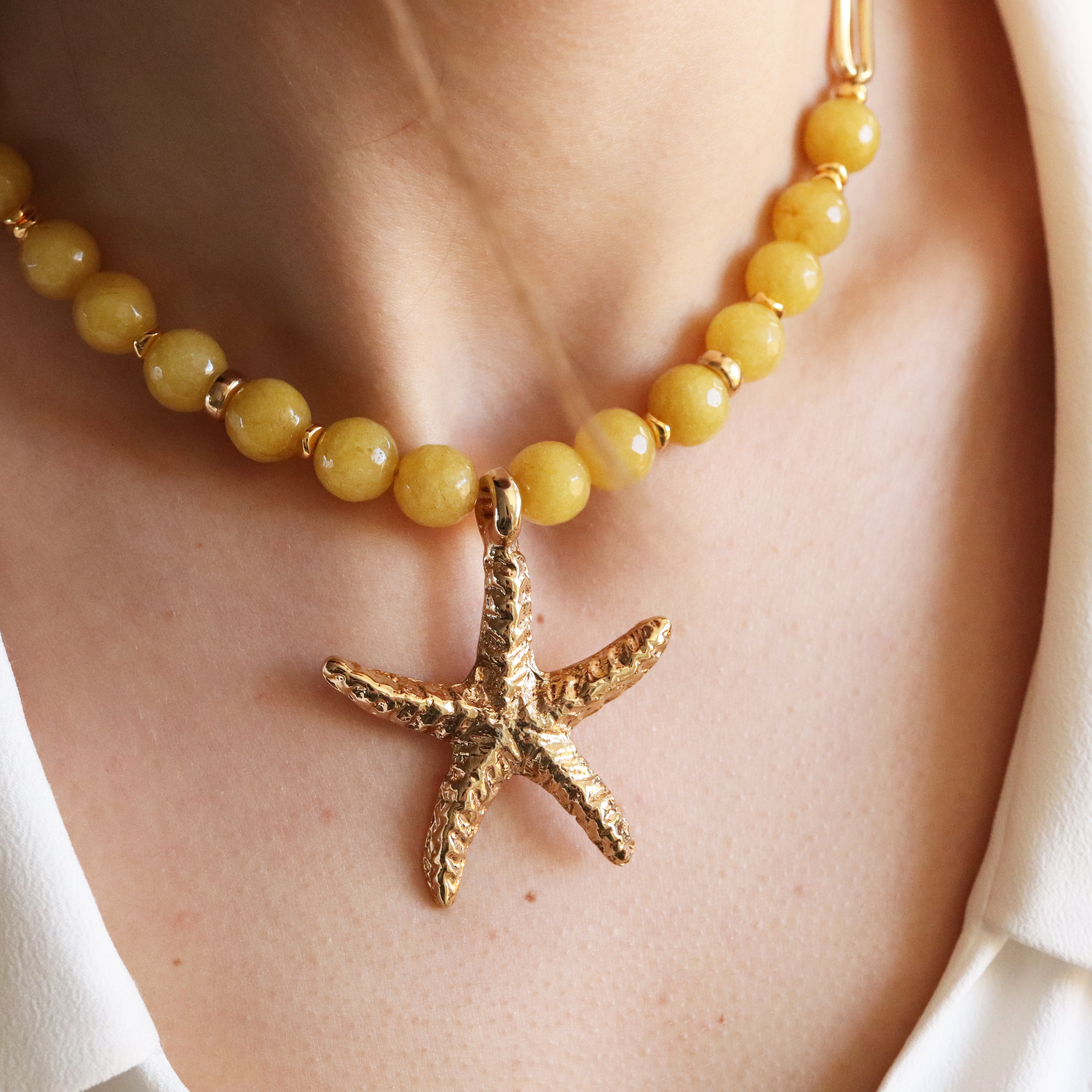Detalle del collar Serenity amarillo, piezas doradas y toque de color — Émolo