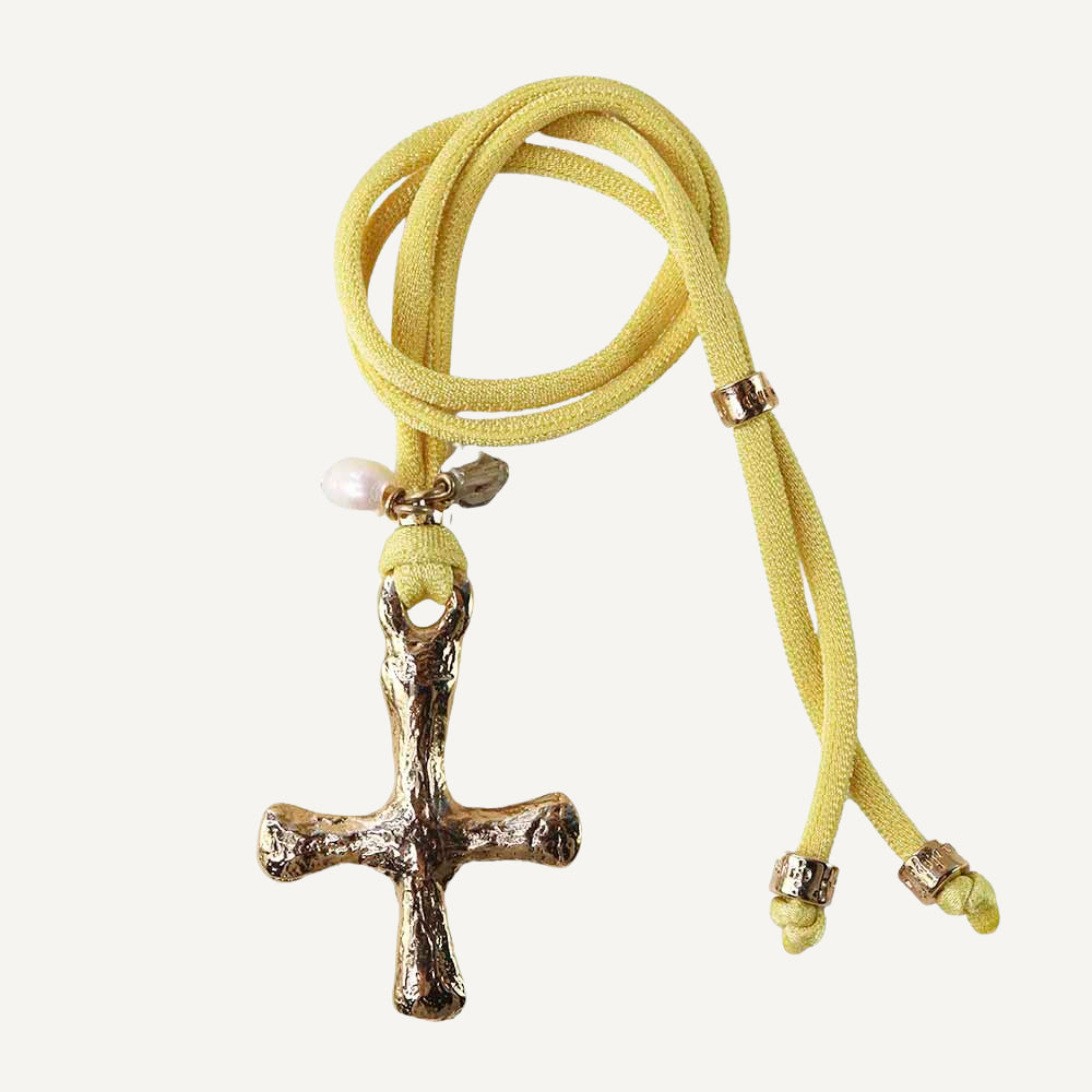 Collier ajustable en soie élastique jaune avec une croix en or.