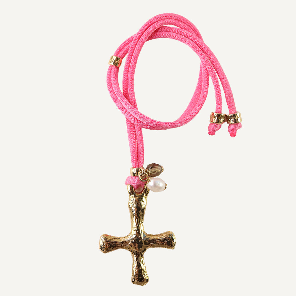 Collier ajustable en soie élastique fuchsia avec une croix en or.