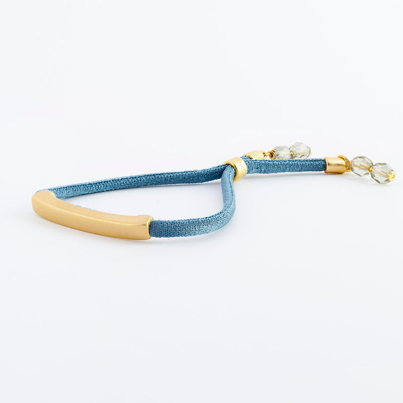 Pulsera con seda elástica color azul con pieza dorada para mujer