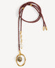 Collar largo Nimbo Monsul burdeos de Emolo con cordón trenzado, aro dorado irregular y cuentas verde y blanca