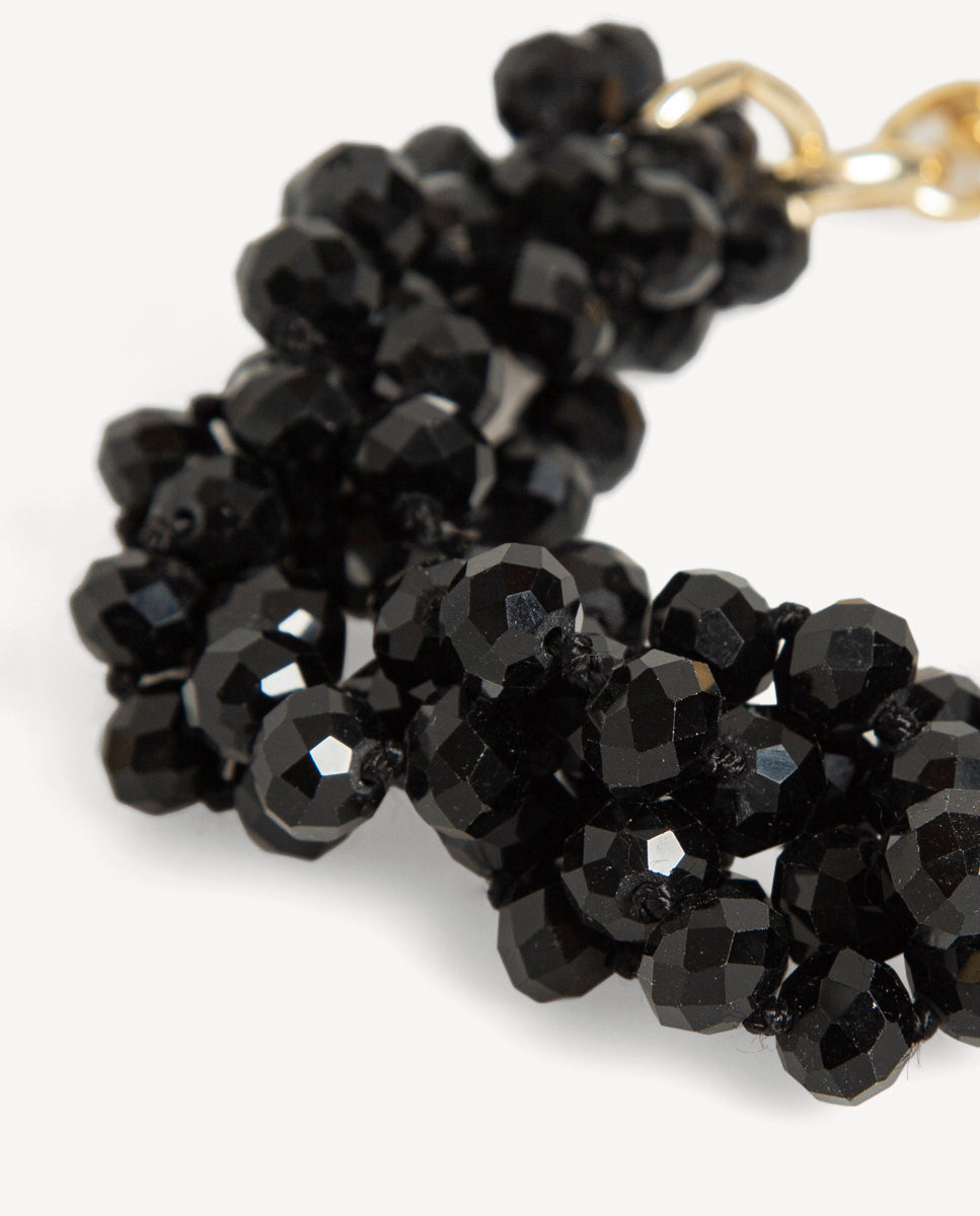 Detalle del collar Odri Sienna negro de Emolo con varias hileras de cuentas negras facetadas y eslabones dorados