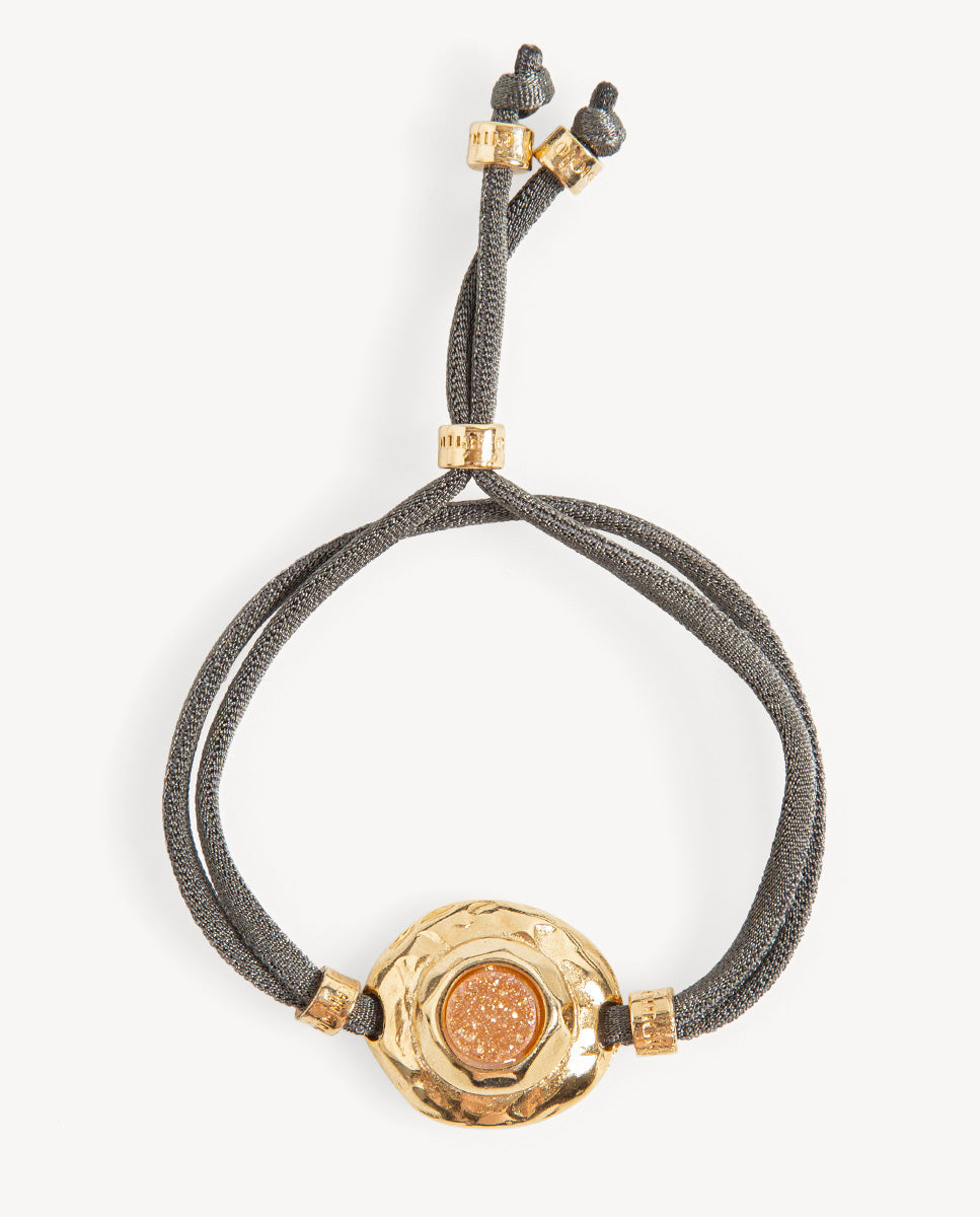 Pulsera Solmara de Emolo con cordón gris ajustable y medallón dorado texturizado con drusa circular dorada