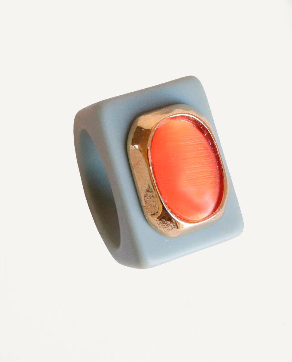 Anillo Emolo en verde sage con selenita naranja de talla ovalada XXL y engaste dorado, vista frontal sobre fondo claro