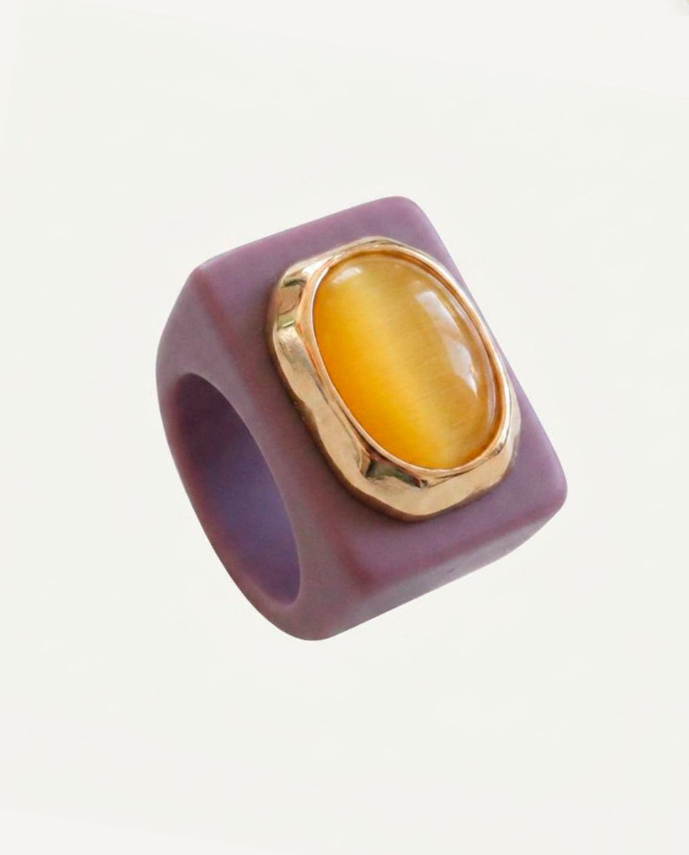 Anillo Emolo en tono mora con selenita amarilla de talla ovalada XXL y engaste dorado, vista frontal sobre fondo claro