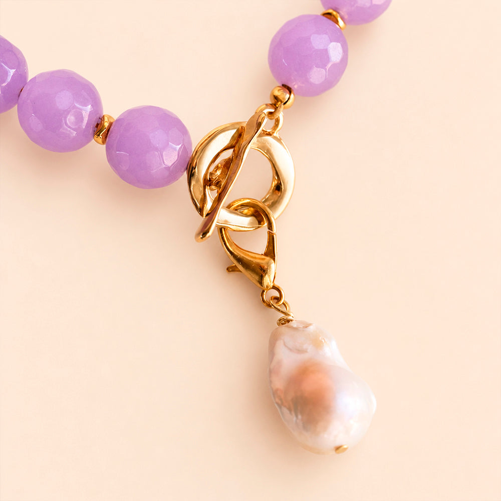 Detalle del cierre dorado y la perla barroca del collar BÁVARO en color malva