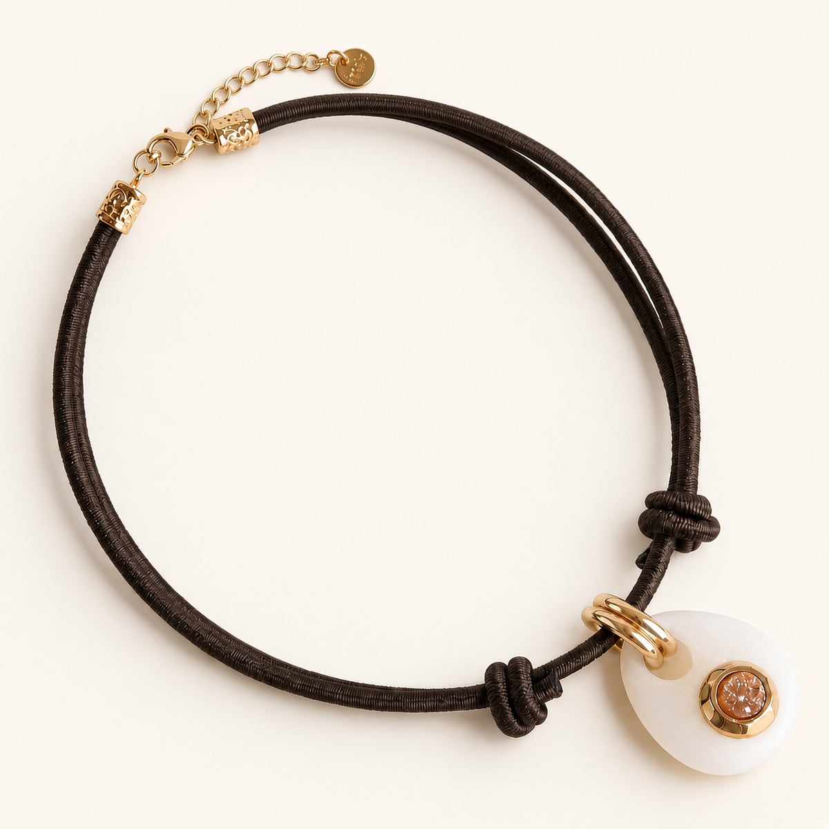 Collar Sianna Milu Hielo de Emolo con cordón marrón, colgante blanco y detalles dorados
