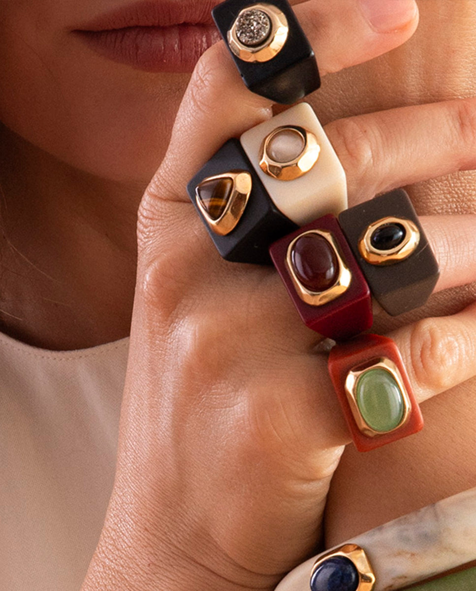 Modelo con el anillo negro de ojo de tigre de Emolo y otros anillos oversize de piedras naturales de la colección